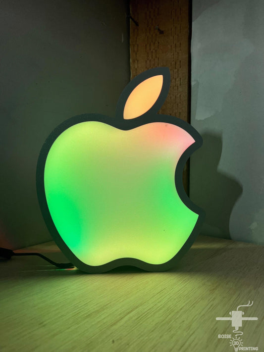 a glowing apple shaped object sitting on top of a wooden table